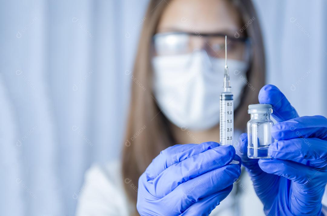 vacina nas mãos do pesquisador, médica segura seringa e garrafa com vacina para cura de coronavírus