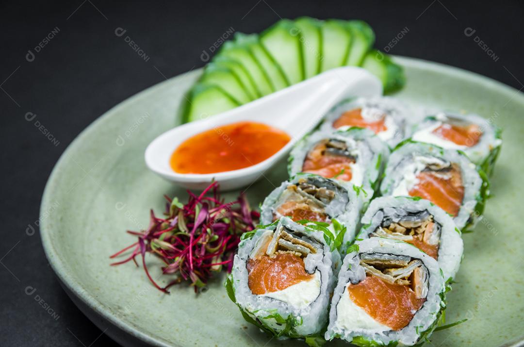 Perfect sushi, traditional Japanese cuisine. Delicious uramaki with sweet and sour sauce on decorated plate