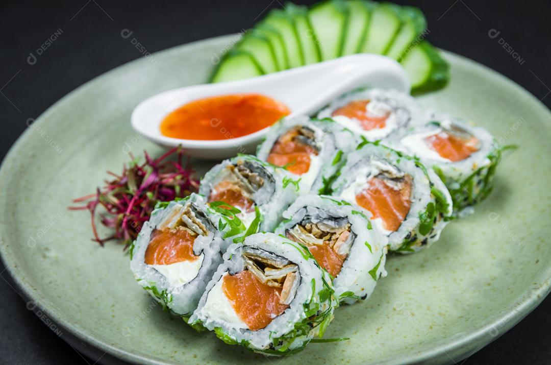 Sushi perfeito, cozinha tradicional japonesa. Delicioso uramaki com molho agridoce no prato decorado