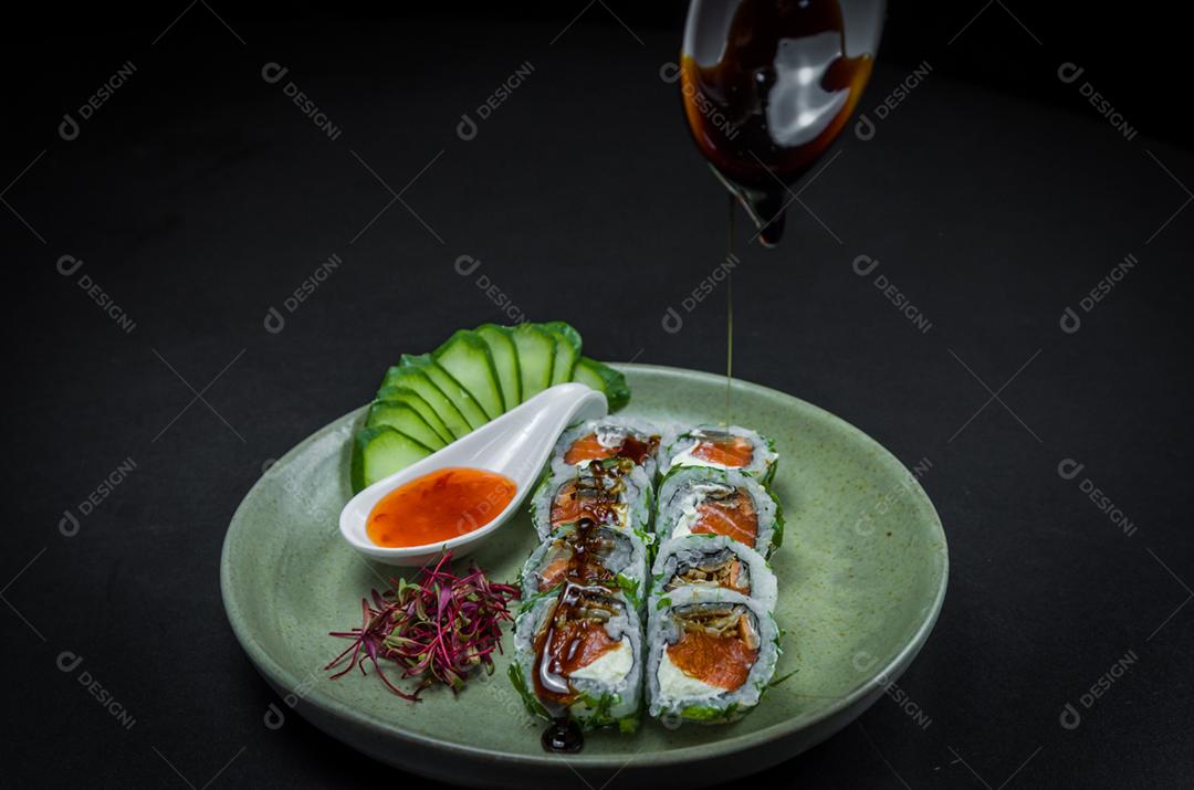 Sushi perfeito, cozinha tradicional japonesa. Delicioso uramaki com molho agridoce no prato decorado