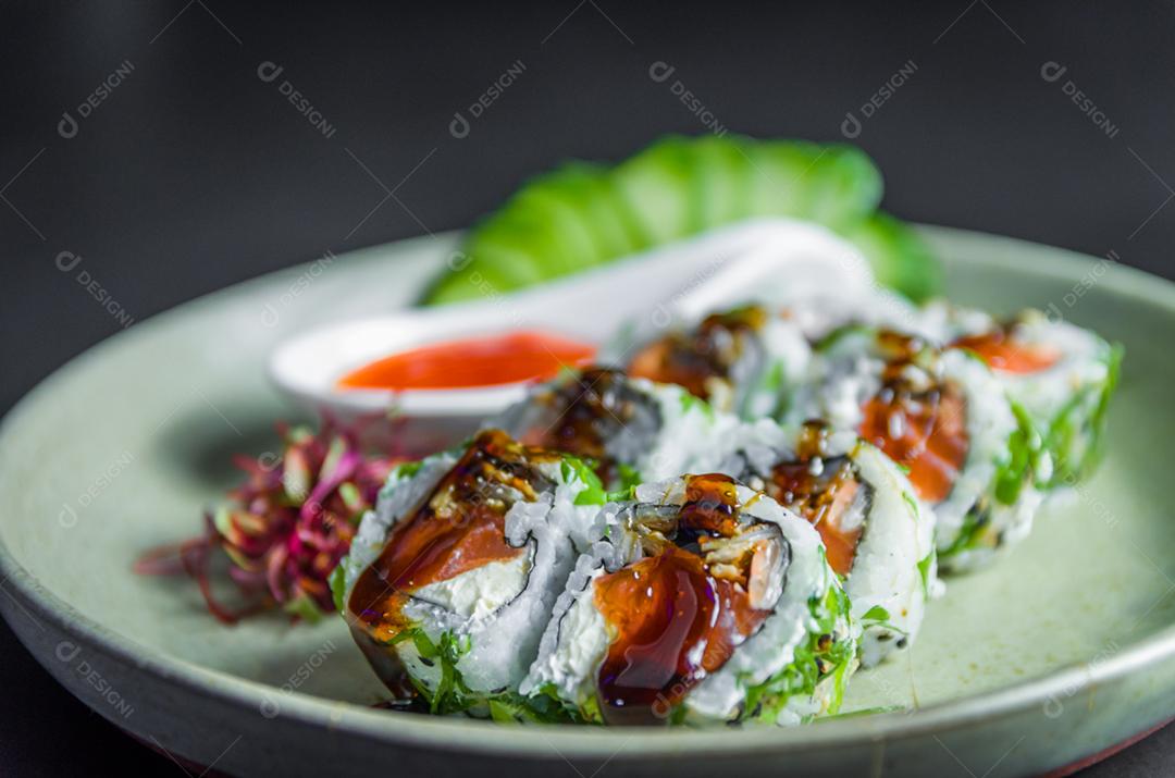 Perfect sushi, traditional Japanese cuisine. Delicious uramaki with sweet and sour sauce on decorated plate