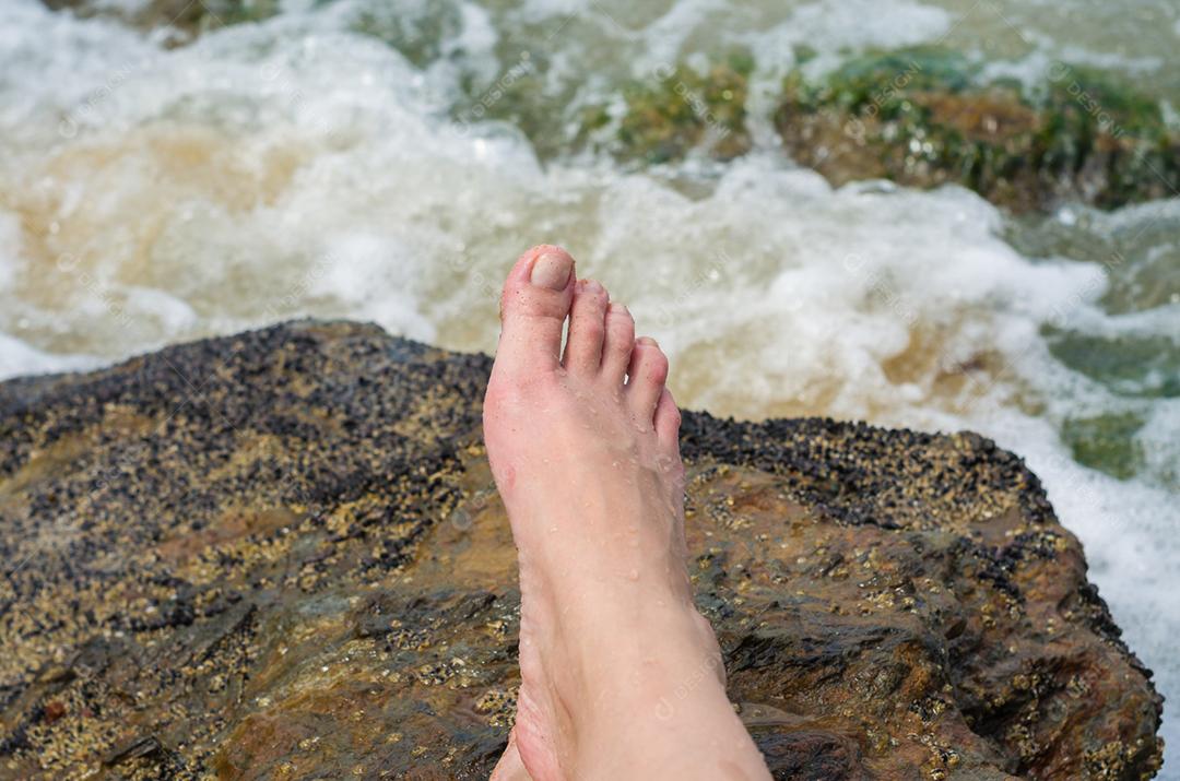 Grande conceito de relaxamento, pernas de mulher na pedra na praia