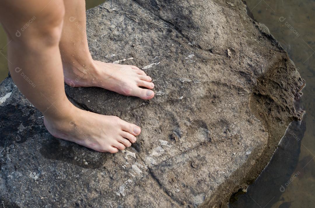 Conceito de caminhada, aventura, pernas de mulher, pisando na pedra.