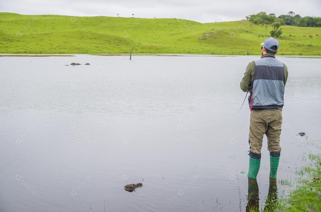 Pescador de black bass pescando dentro do lago
