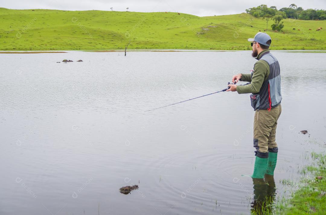 Pescador de black bass pescando dentro do lago
