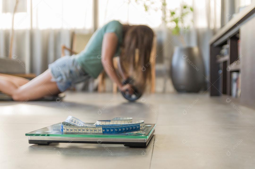 Conceito de falha na perda de peso, escala em primeiro plano e mulher frustrada frustrada em segundo plano.
