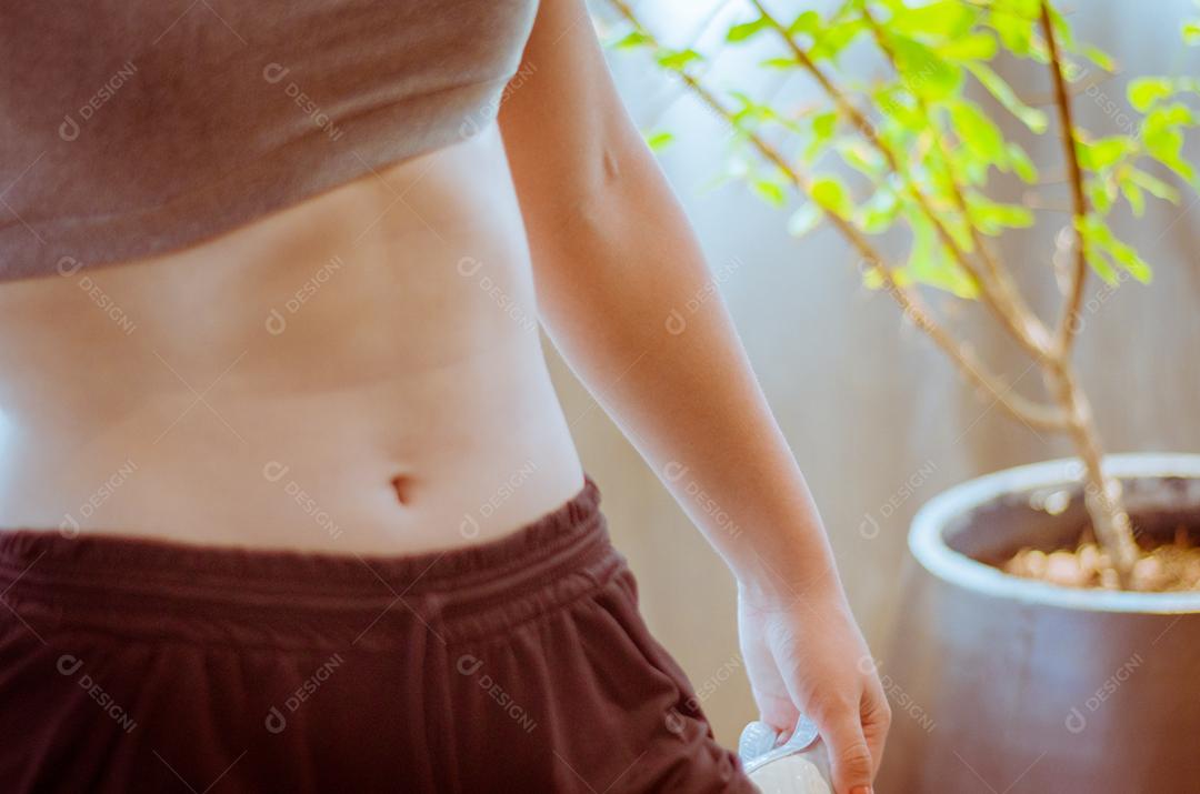 Feche de torso de mulher em forma após o treino. Fêmea com músculos abdominais perfeitos.