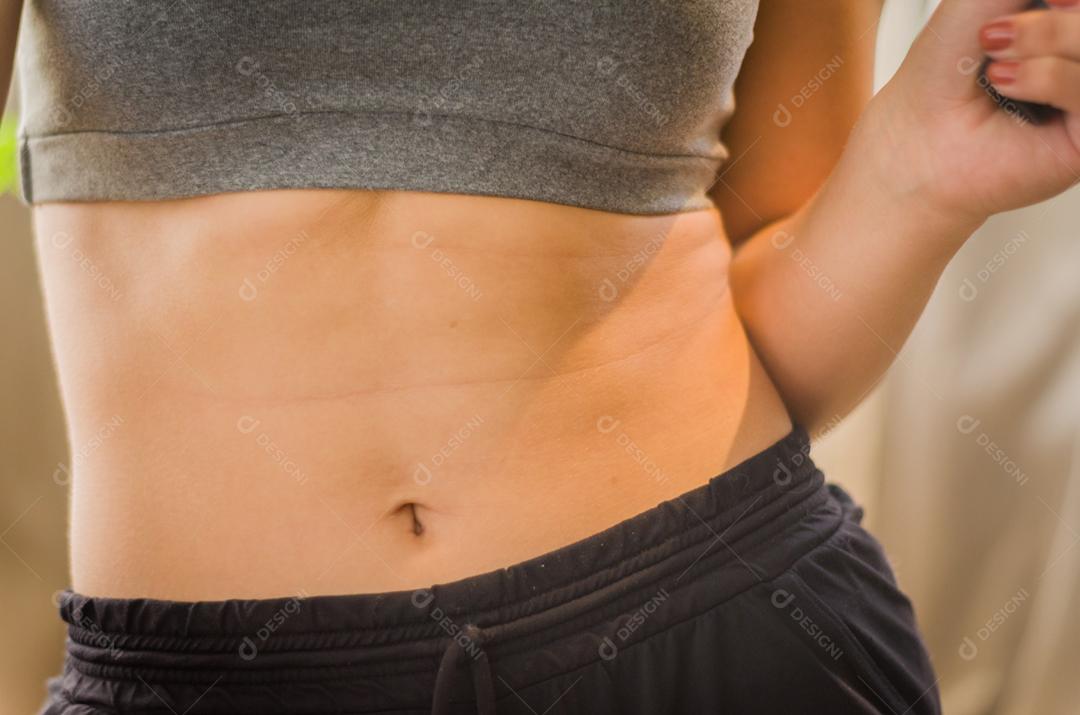 Feche de torso de mulher em forma após o treino. Fêmea com músculos abdominais perfeitos.