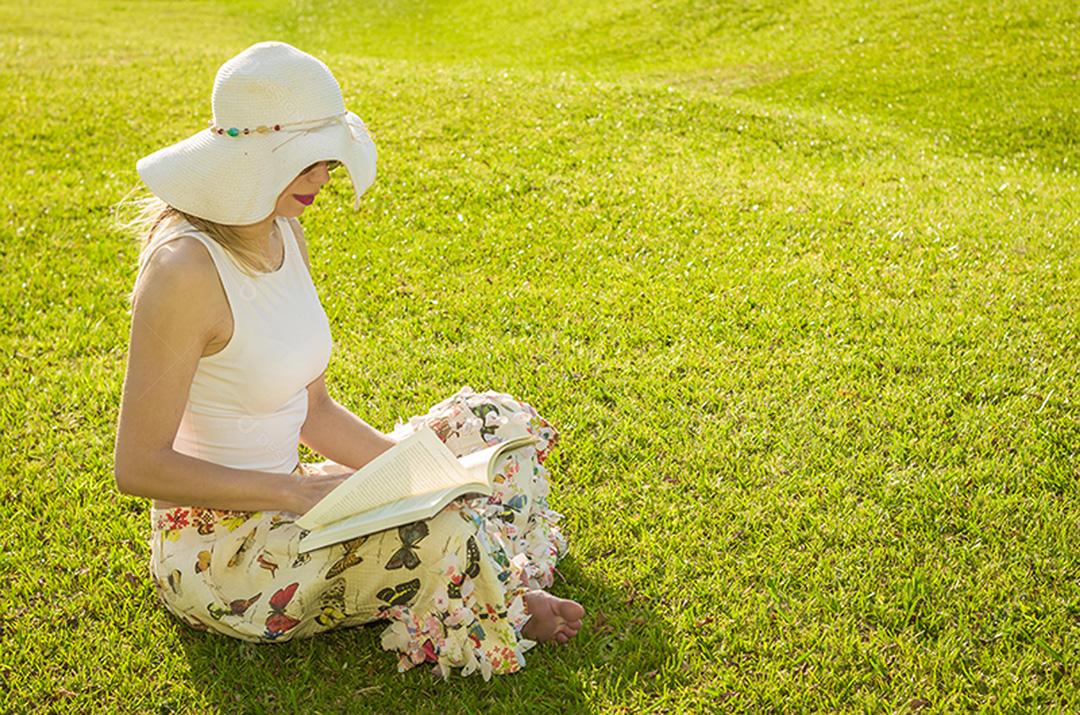 Linda mulher lendo livro sentado no gramado, visto de cima w