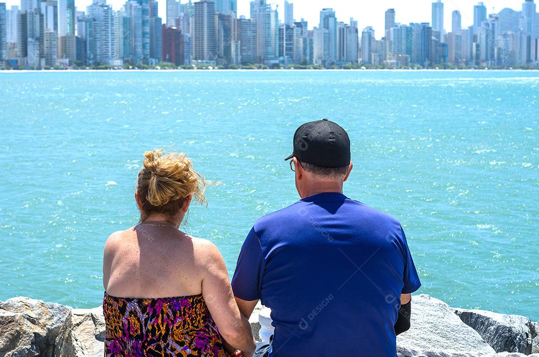Casal de velhos olhando para o horizonte, praia, amor.