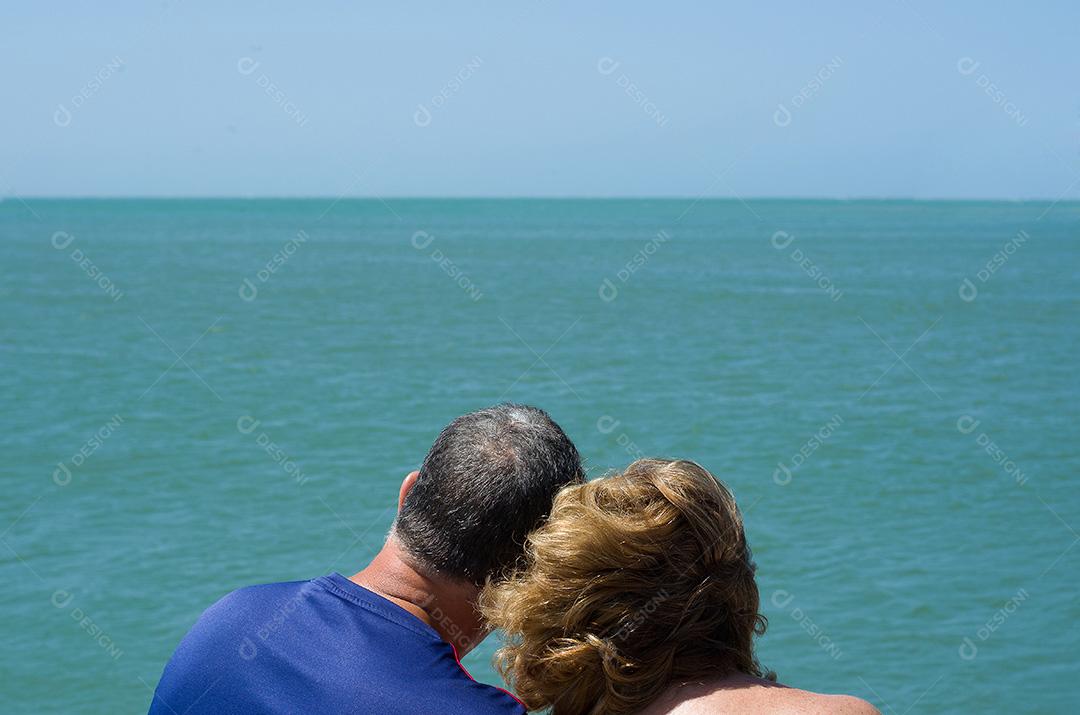 Casal de velhos olhando para o horizonte, praia, amor.