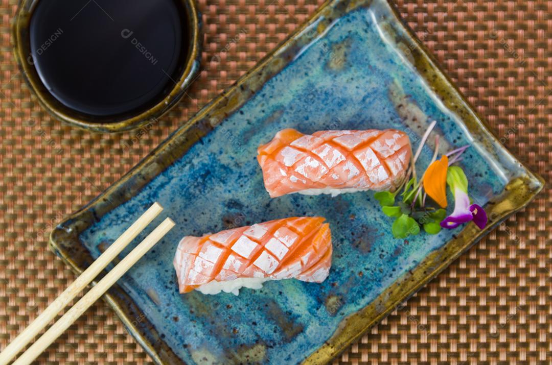 Prato com dois elegantes nigiri sushi (nigirizushi) com cortes de faca em formato de diamante.