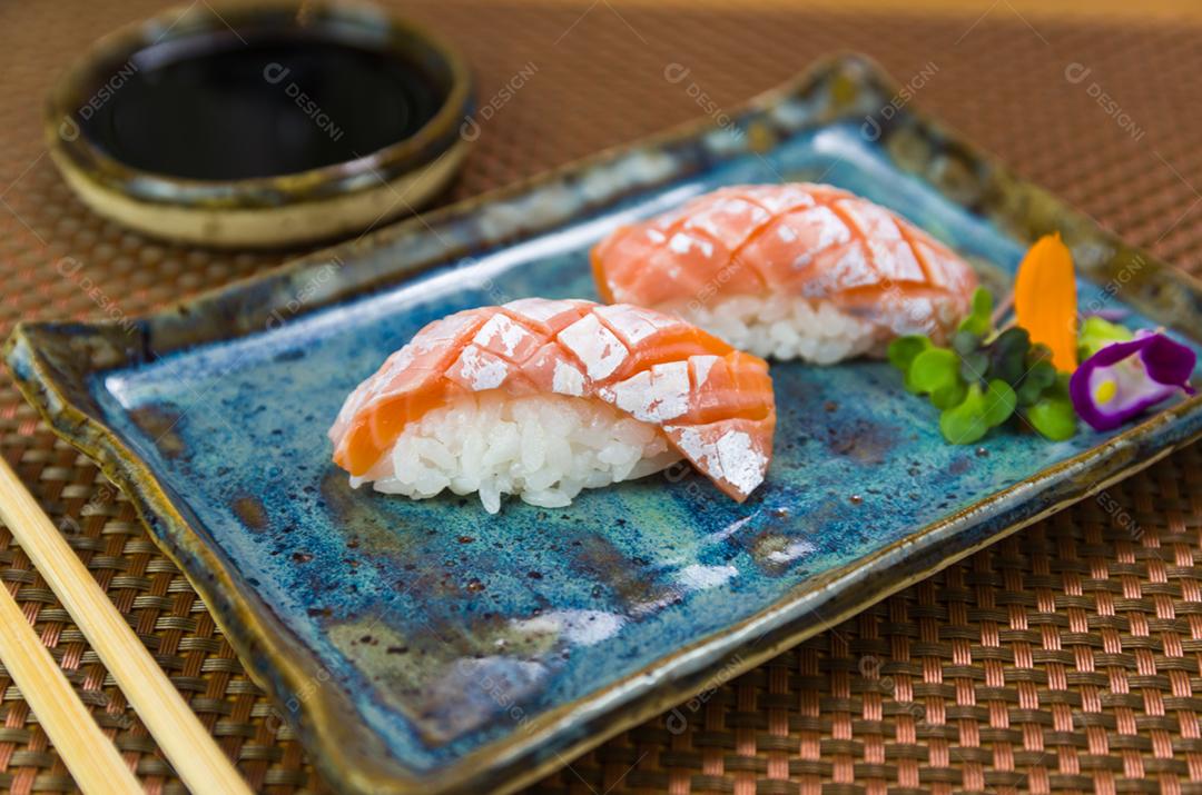 Prato com dois elegantes nigiri sushi (nigirizushi) com cortes de faca em formato de diamante.