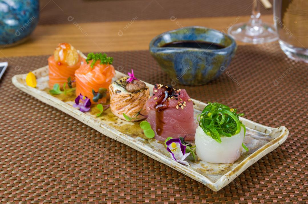 Prato decorado com diferentes sabores de sushi gunkan elegante, salmão, atum, linguado