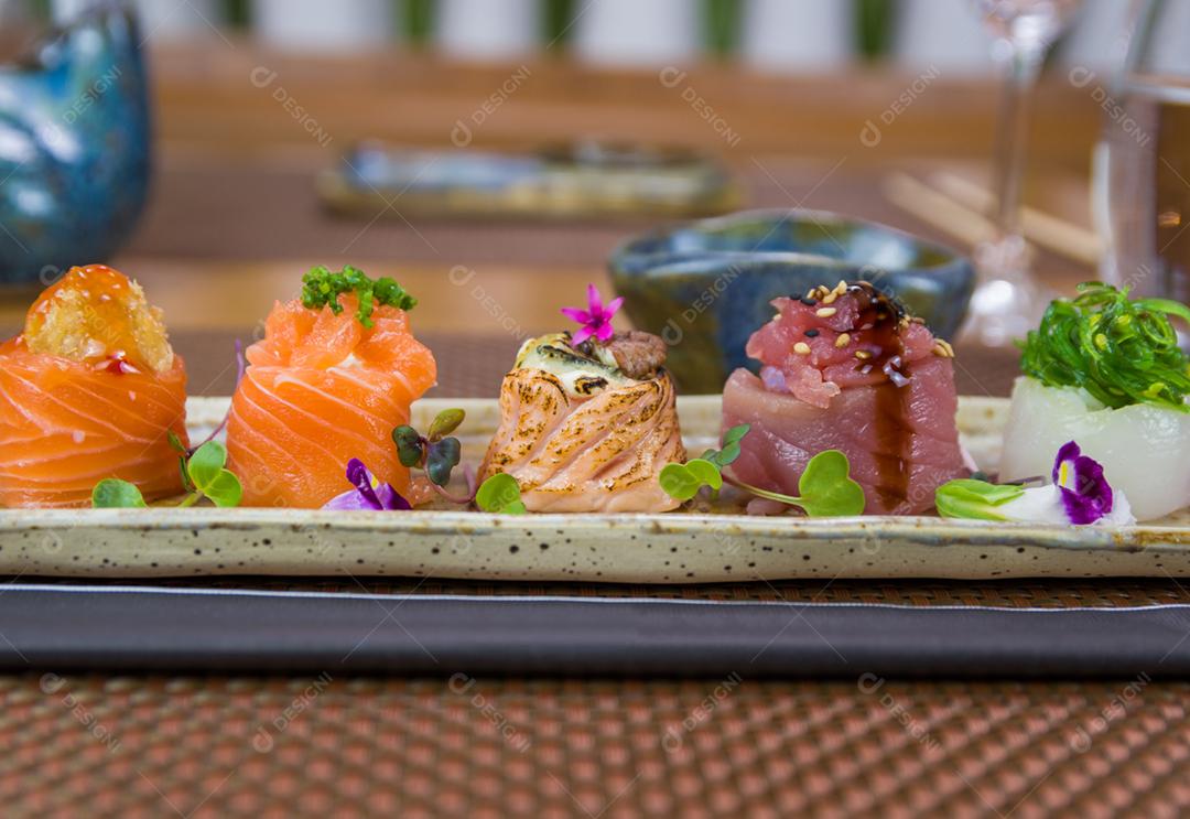 Prato decorado com diferentes sabores de sushi gunkan elegante, salmão, atum, linguado