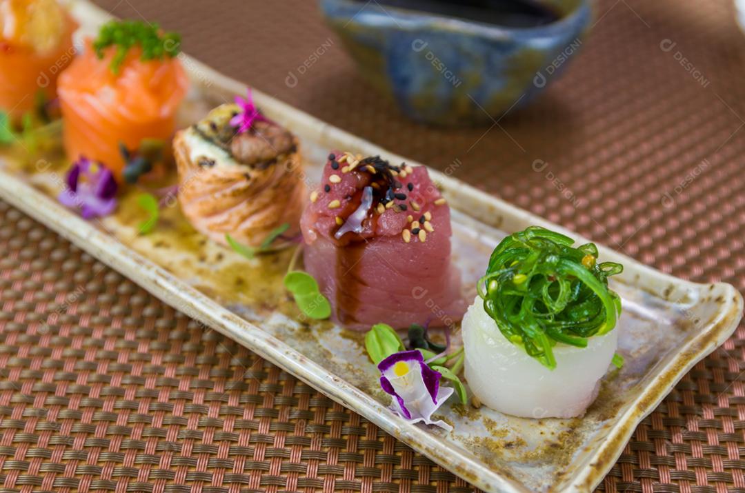 Prato decorado com diferentes sabores de sushi gunkan elegante, salmão, atum, linguado