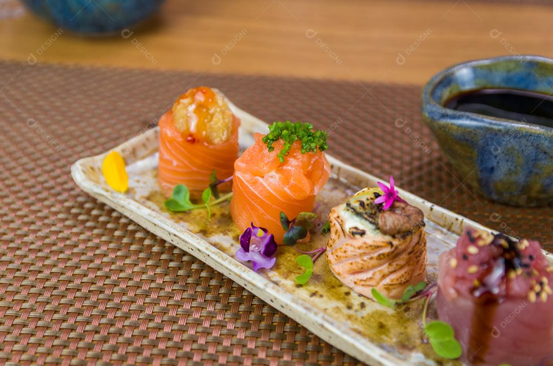 Prato decorado com diferentes sabores de sushi gunkan elegante, salmão, atum, linguado