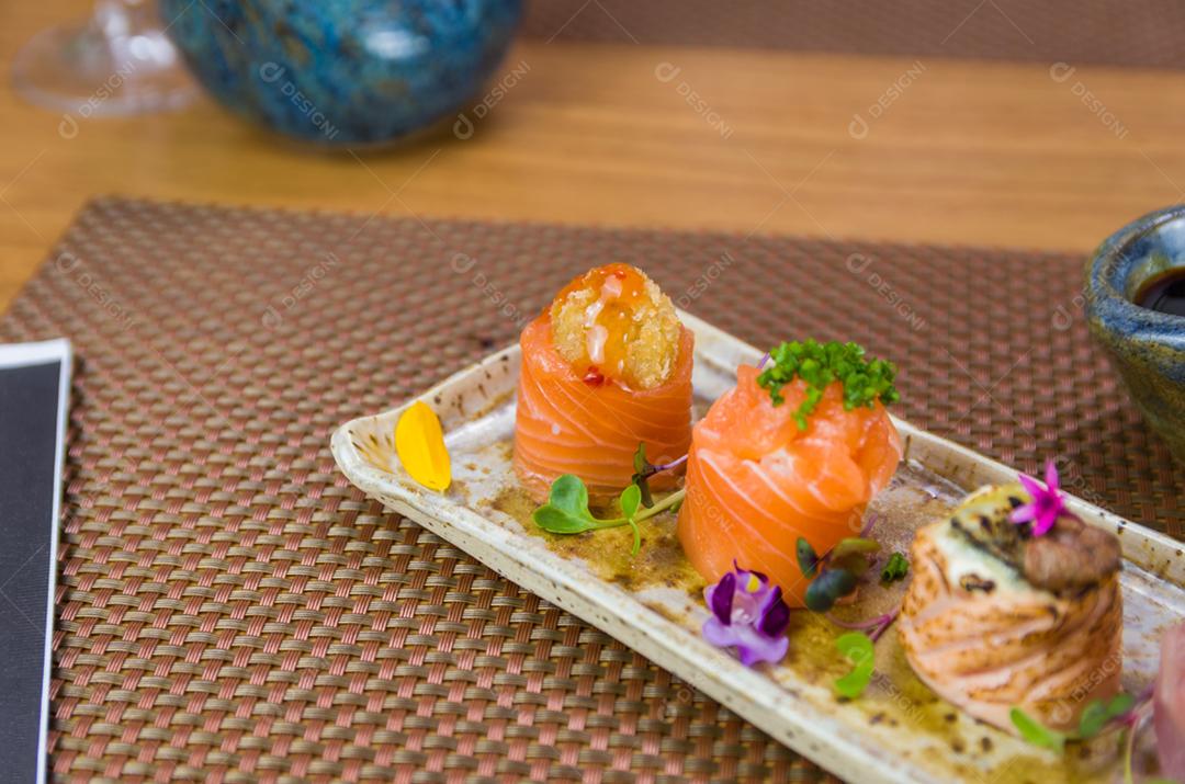 Prato decorado com diferentes sabores de sushi gunkan elegante, salmão, atum, linguado