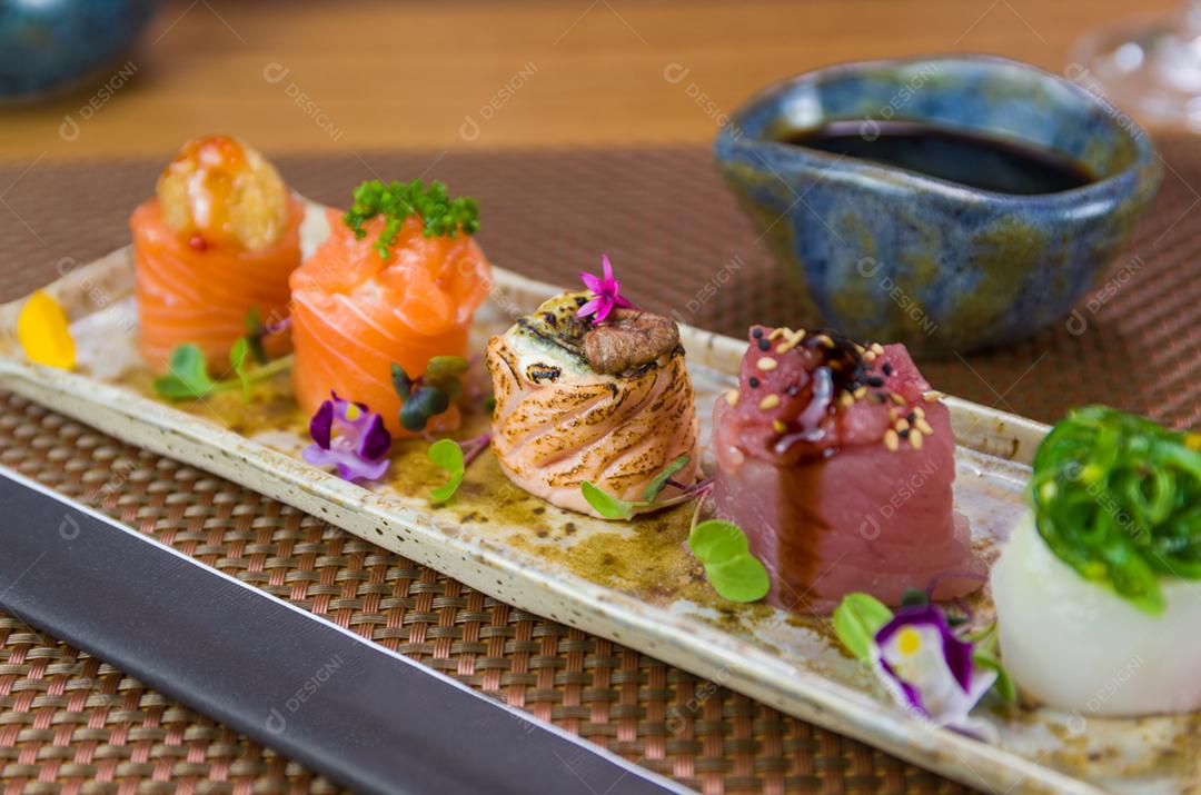Prato decorado com diferentes sabores de sushi gunkan elegante, salmão, atum, linguado