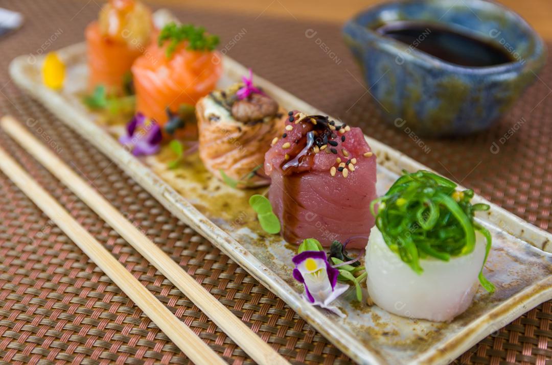 Prato decorado com diferentes sabores de sushi gunkan elegante, salmão, atum, linguado