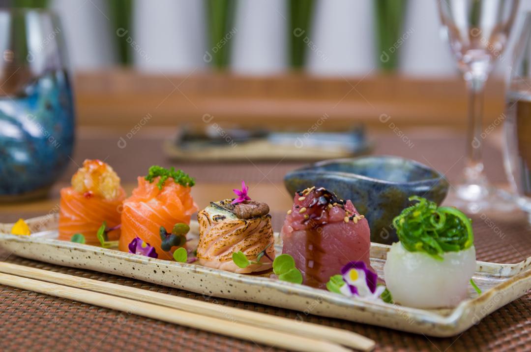 Prato decorado com diferentes sabores de sushi gunkan elegante, salmão, atum, linguado