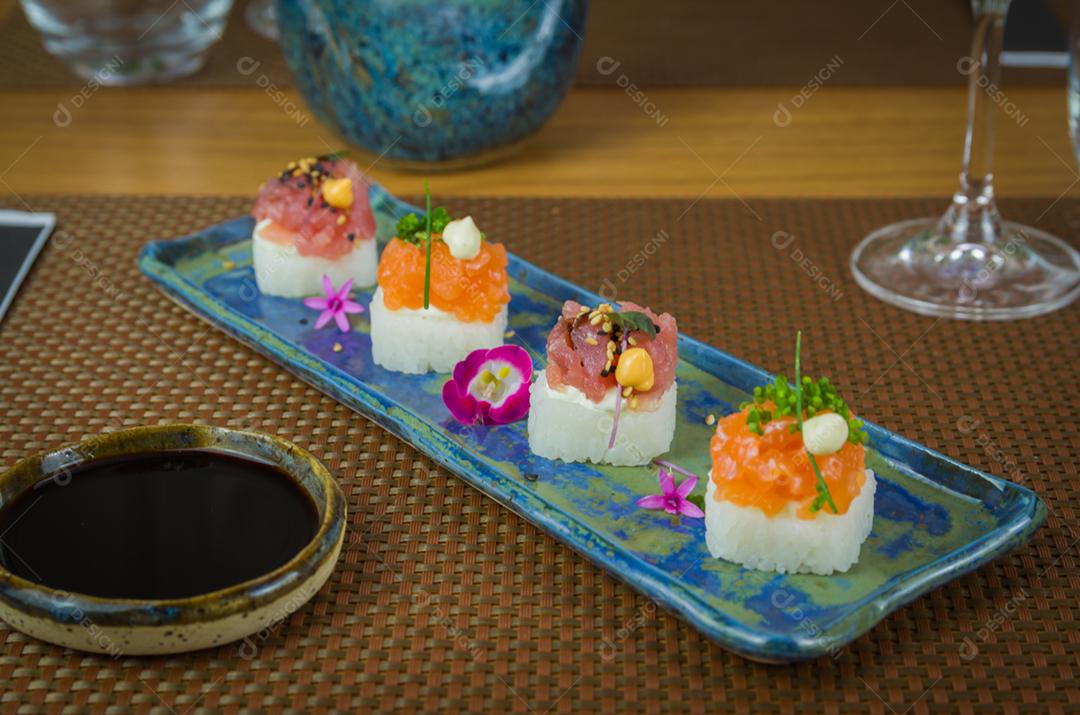Delicioso sushi premium de salmão e atum Oshizushi em um prato de porcelana artesanal decorado.