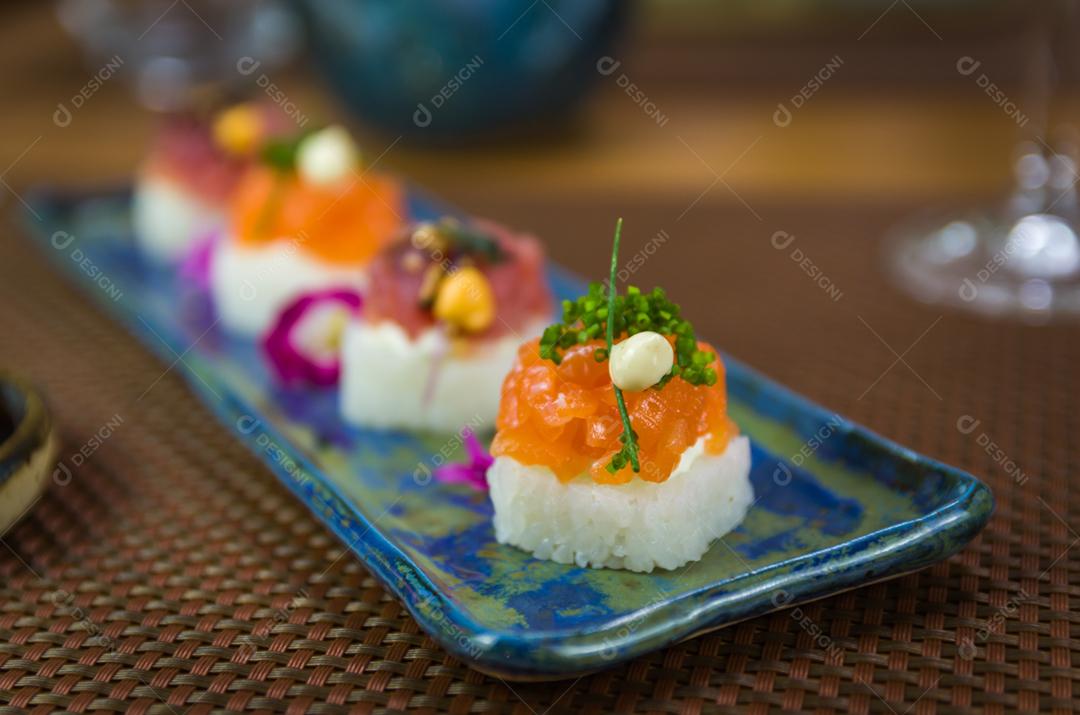 Delicioso sushi premium de salmão e atum Oshizushi em um prato de porcelana artesanal decorado.