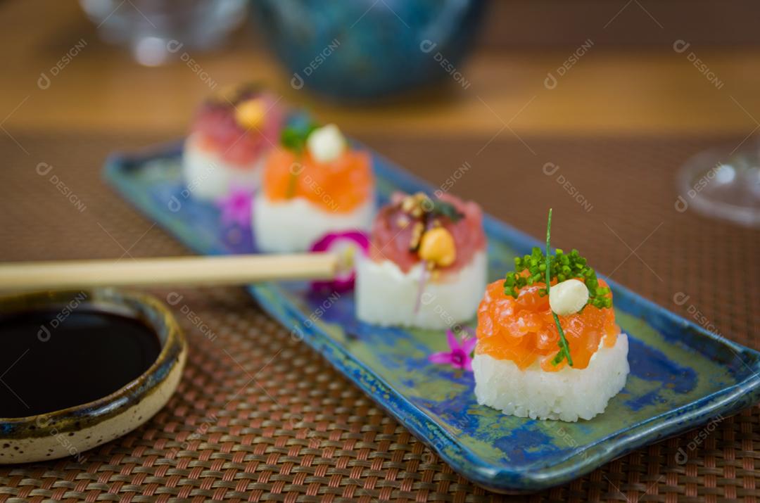 Delicioso sushi premium de salmão e atum Oshizushi em um prato de porcelana artesanal decorado.