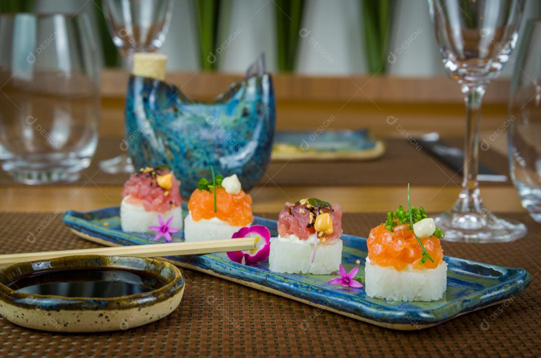 Delicioso sushi premium de salmão e atum Oshizushi em um prato de porcelana artesanal decorado.