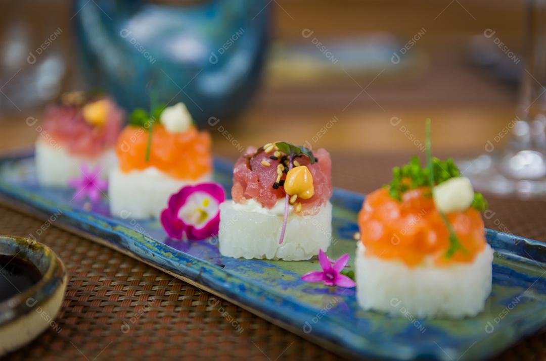 Delicioso sushi premium de salmão e atum Oshizushi em um prato de porcelana artesanal decorado.