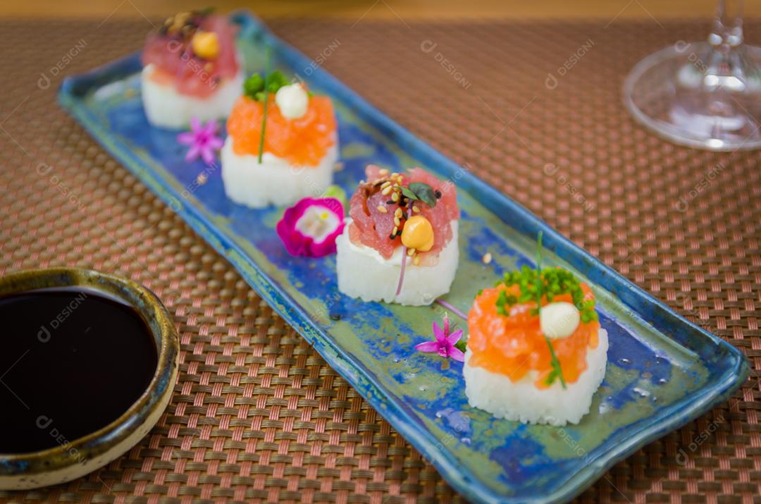 Delicioso sushi premium de salmão e atum Oshizushi em um prato de porcelana artesanal decorado.