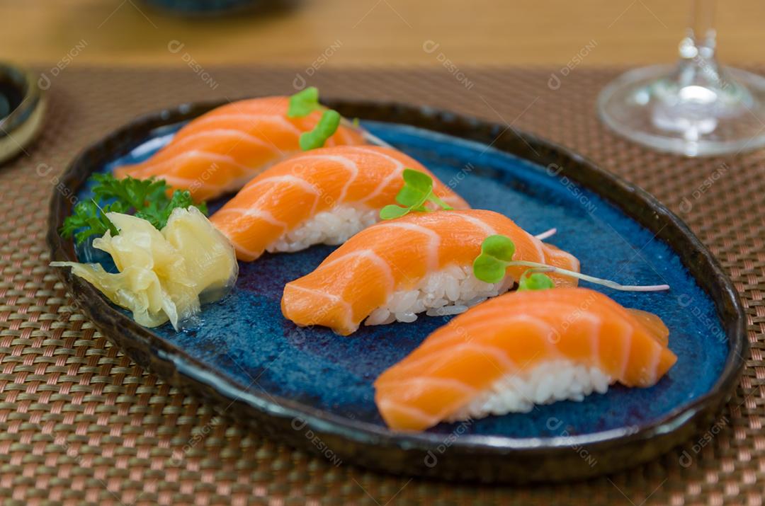 Delicioso nigiri de salmão premium no prato artesanal azul decorado