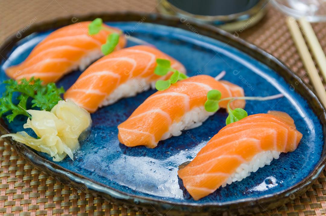 Delicioso nigiri de salmão premium no prato artesanal azul decorado