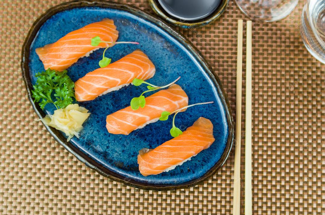 Delicioso nigiri de salmão premium no prato artesanal azul decorado