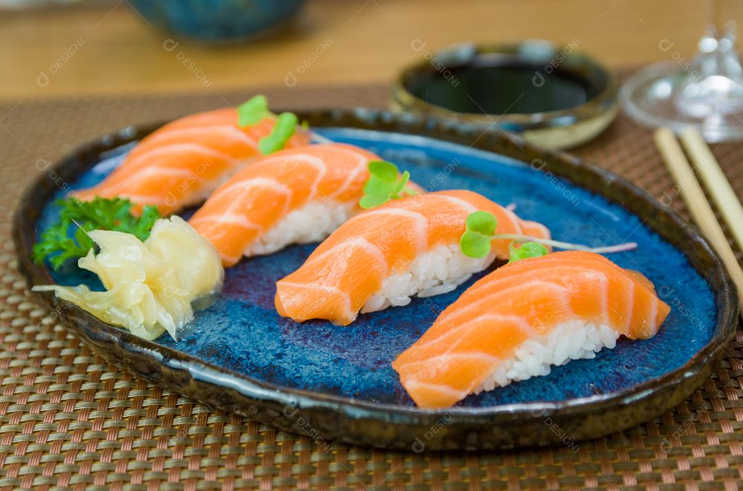 Delicioso nigiri de salmão premium no prato artesanal azul decorado