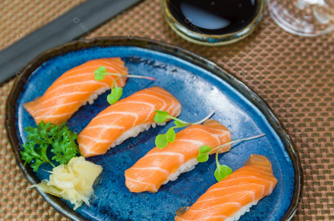 Delicioso nigiri de salmão premium no prato artesanal azul decorado