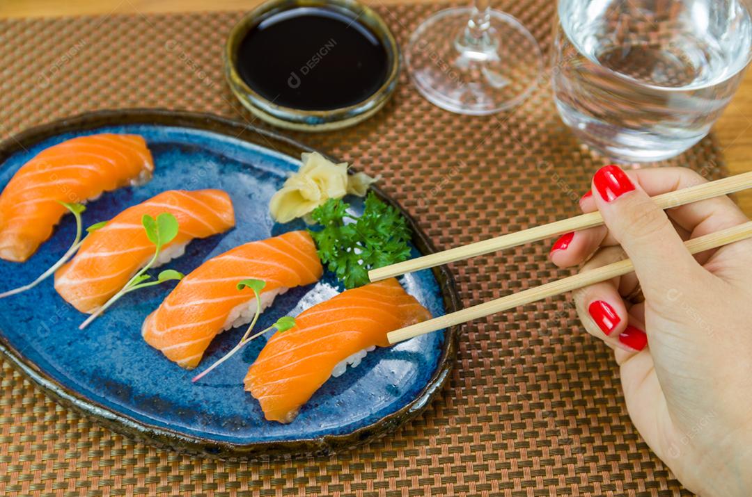 Delicioso nigirizushi de salmão premium no prato artesanal azul decorado