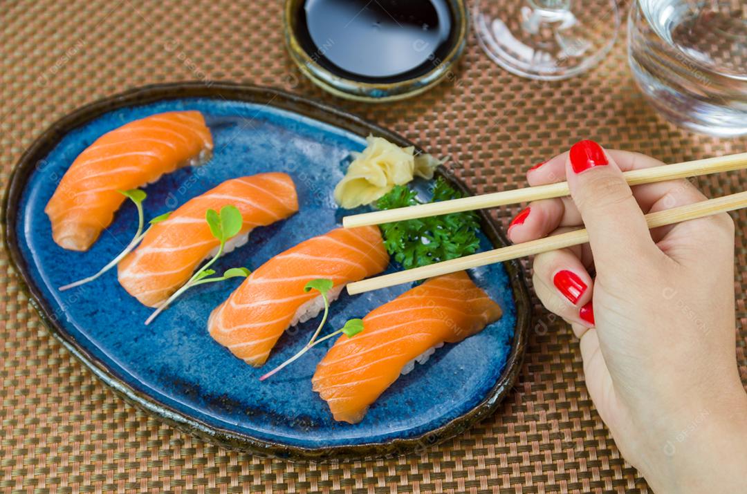 Delicioso nigirizushi de salmão premium no prato artesanal azul decorado