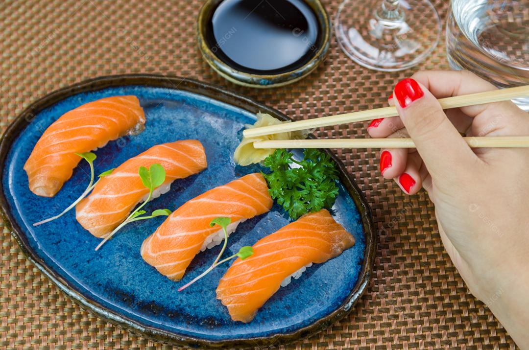 Delicioso nigirizushi de salmão premium no prato artesanal azul decorado