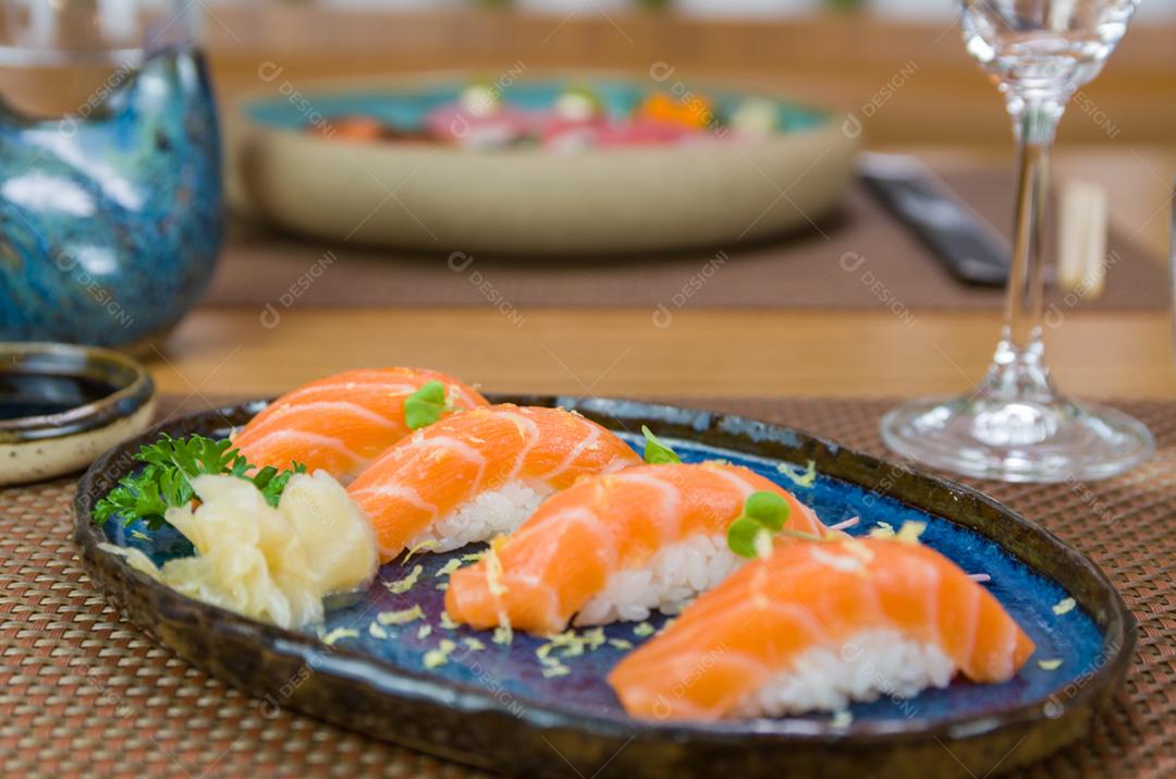 Delicioso nigiri de salmão premium no prato artesanal azul decorado