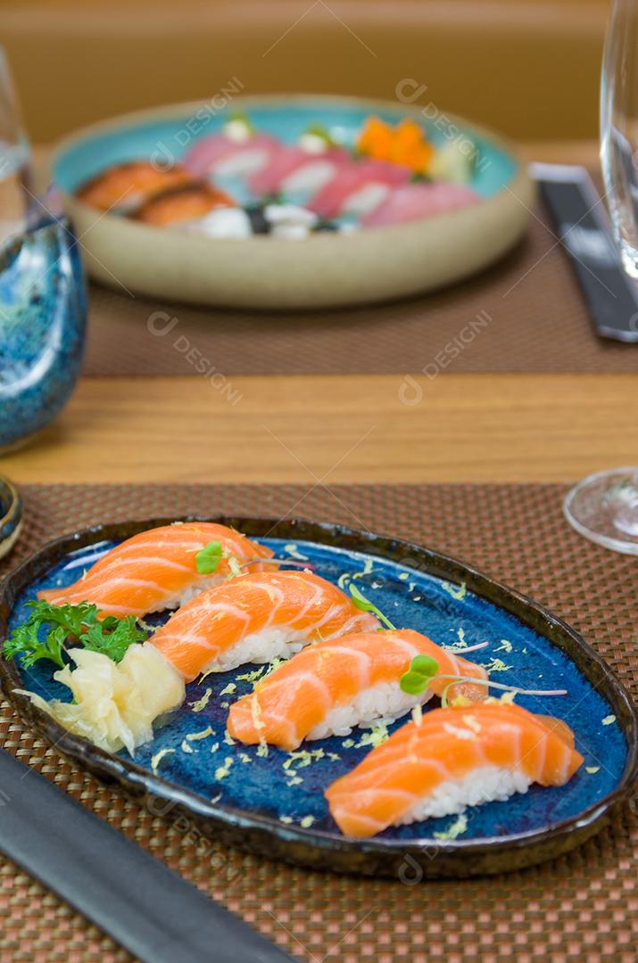 Delicioso nigiri de salmão premium no prato artesanal azul decorado