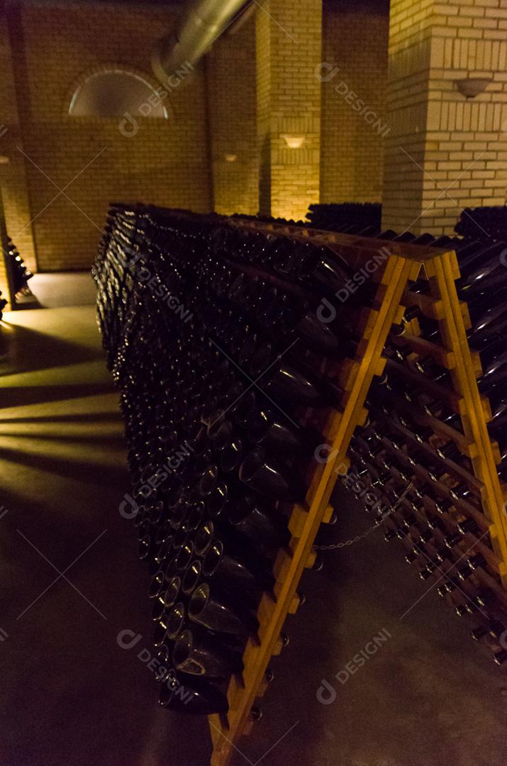 Garrafas nos pupitres para que as leveduras se acumulem no gargalo da garrafa.