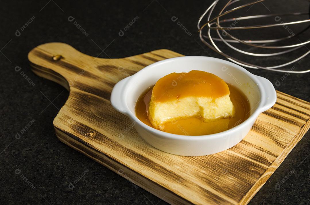 Sobremesa tradicional brasileira, pudim de leite em fundo escuro.