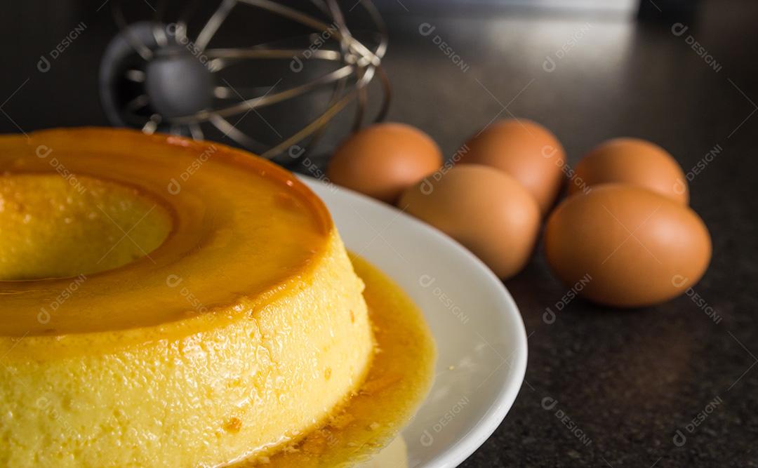 Sobremesa tradicional brasileira, pudim de leite em fundo escuro.