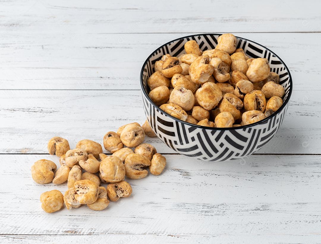 Canjica, ou pipoca de milho branco, pipoca doce em uma tigela sobre mesa de madeira.