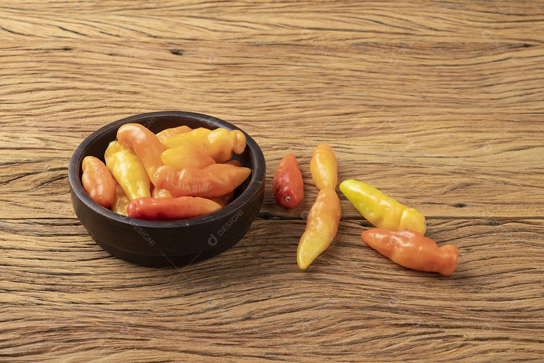 Pimenta de cheiro laranja (cheiro/cheiro) em uma tigela sobre mesa de madeira.