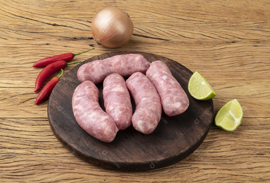 Salsicha de porco sobre tábua de madeira com temperos.