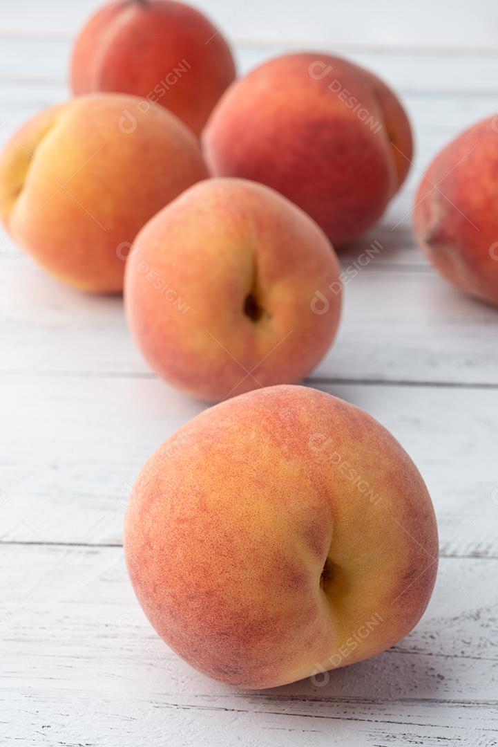 Um grupo de pêssegos sobre a mesa de madeira.