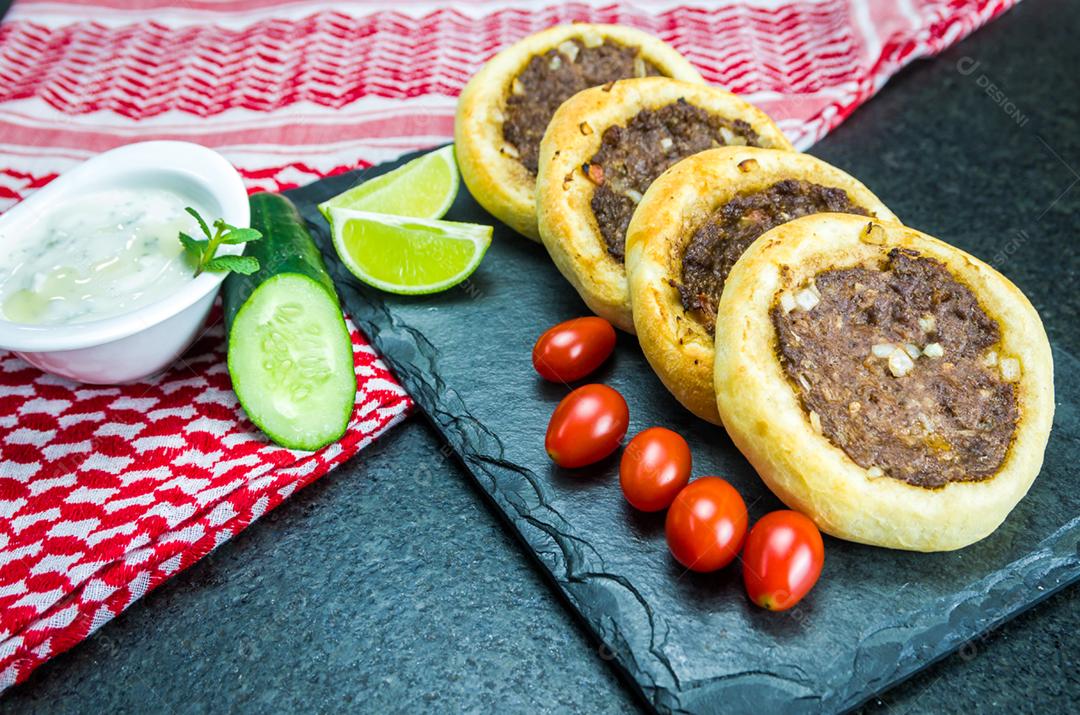 Deliciosa comida libanesa (árabe), esfihas genuínas em uma placa de ardósia com tomates, limões