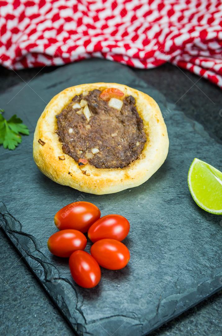 Deliciosa comida libanesa (árabe), esfihas legítimas em um fundo de granito preto com tomates
